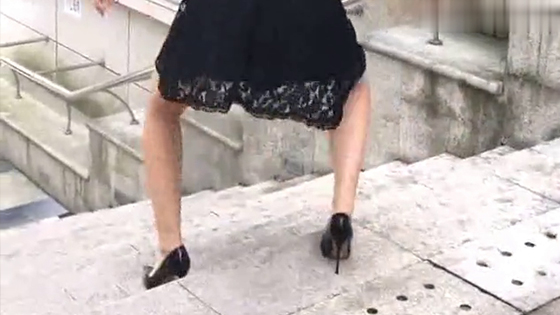 Beautiful woman demonstrates the wrong way to wear high heels down stairs.