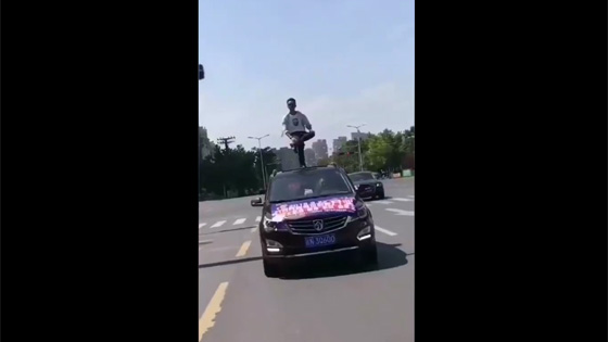 The man was so amazing that he actually stood on a moving car with one foot. 