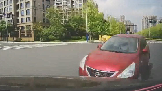 A vehicle running through a red light directly hit the video vehicle against the sky.
