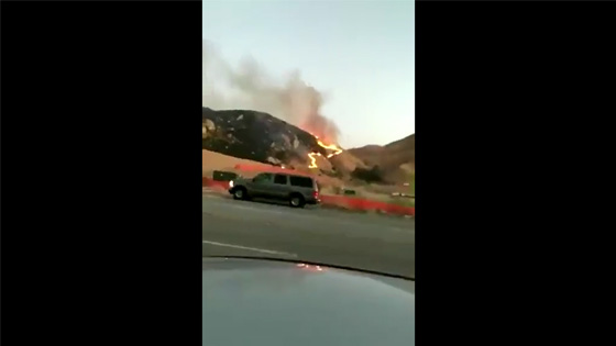 A wildfire broke out in the distance,and this guy took out his magic device.
