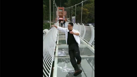 The man was walking on the glass bridge and suddenly the glass under the bridge cracked.