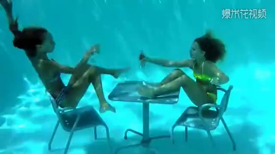 Two little girls play underwater games, swimming skateboards and bicycles