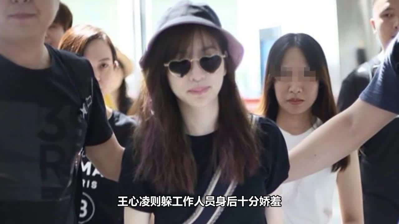 Wang Xinling wears heart-shaped sunglasses for leisure and hides behind the staff.