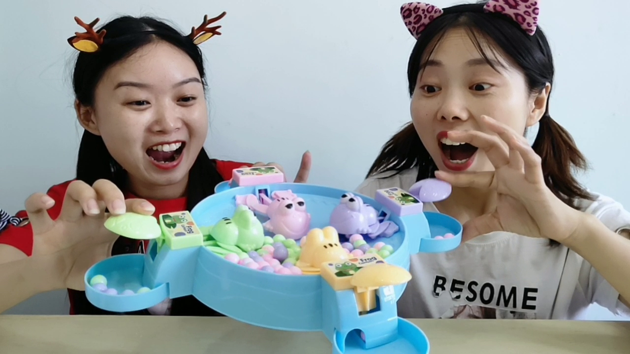 Two girlfriends play with "frogs eat beans", which is more funny than watching who eats more quickly.