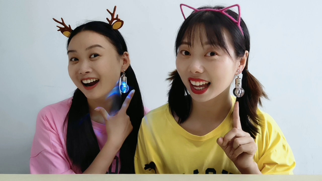 Two girlfriends wear "light bulb earrings" to show off their stinky beauty. It's funny. They fight to be beautiful girls.