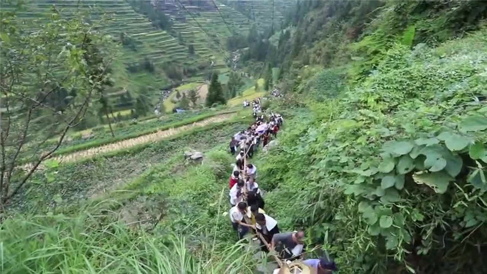 In the countryside of Guizhou, hundreds of people climb mountains in the village. Are they acting like a long dragon?