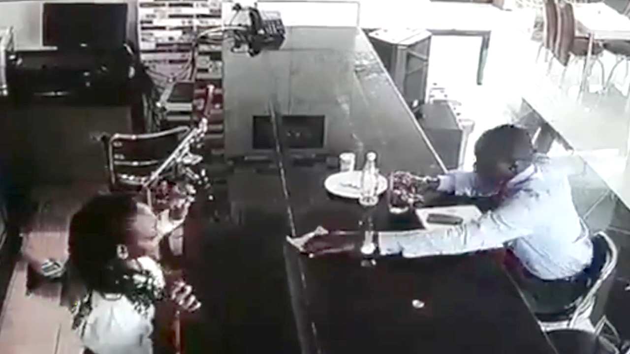 The man opened the bar clerk with a large bill and stole five bottles of wine from the counter in an instant.