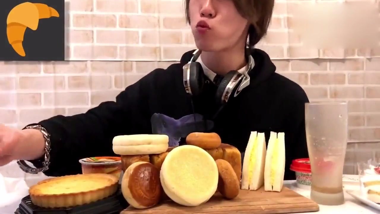 Japanese Big Stomach King: The earphone kid eats all kinds of bread, bites down, looks very satisfied.