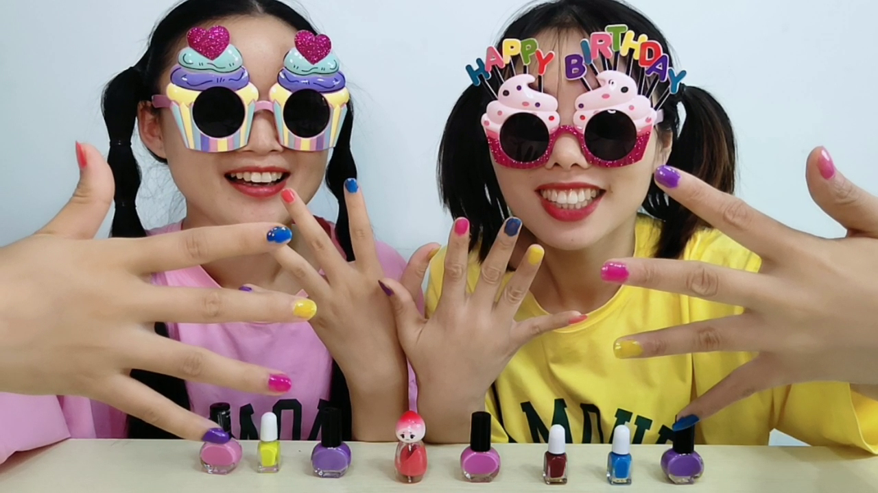 The two girls wear strange "cake glasses", paint each other with colorful nails, and enjoy more fun.