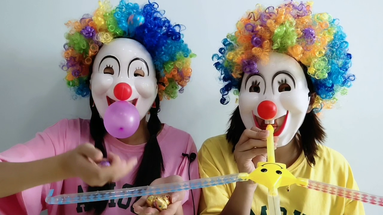 Two girlfriends compete to play the "clown", blow up balloons and throw eggs.